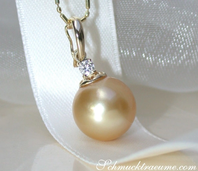 Goldener Südseeperlen-Anhänger mit Brillant, detailreich, zart, elegant, auf weißer Seide präsentiert. Goldener Südseeperlen-Anhänger mit Brillant, detailreich, zart, elegant, auf weißer Seide präsentiert.