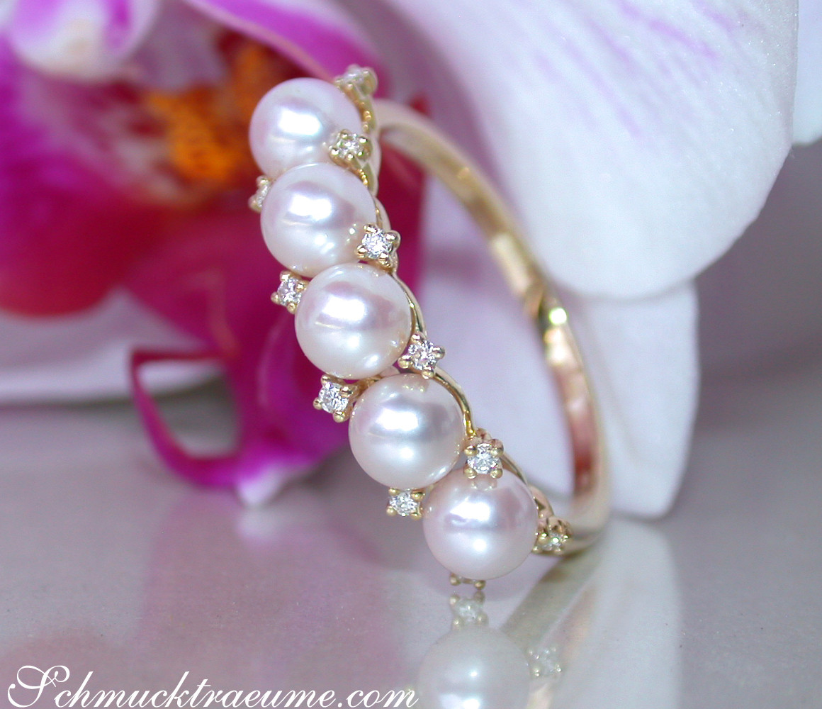 Perlenring mit Diamanten, Detailaufnahme, Blume im Hintergrund