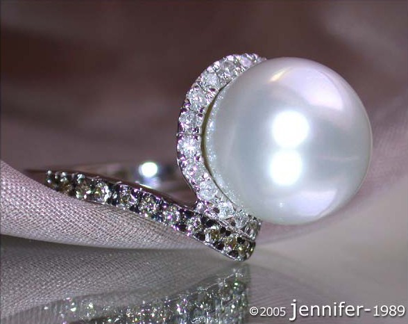 Klassischer Südseeperlen-Ring mit braunen & weißen Brillanten, Detailaufnahme auf silberner Seide