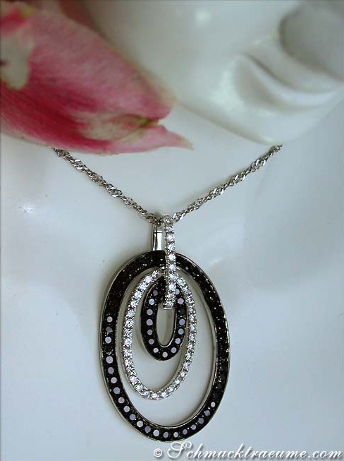 Ovaler Diamantanhänger mit schwarzen und weißen Steinen, Detailaufnahme, auf weißem Hintergrund.