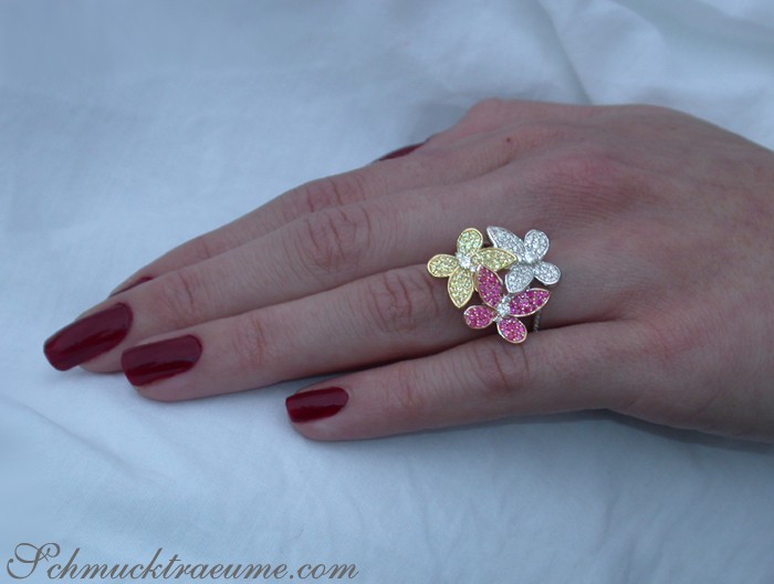 Diamant-Schmetterling-Ring mit Saphiren und Rubinen auf weißer Hand.
