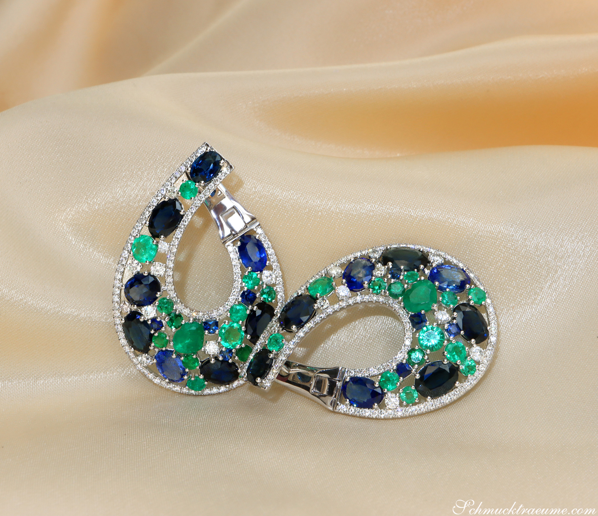 Luxuriöse Saphir-Ohrgehänge mit Smaragden und Brillanten auf Seidenvorhang, Detailaufnahme