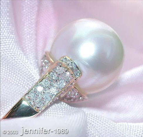 Detailaufnahme des Prächtigen Südseeperlen-Rings mit Brillanten-Kragen auf weichem Stoff.