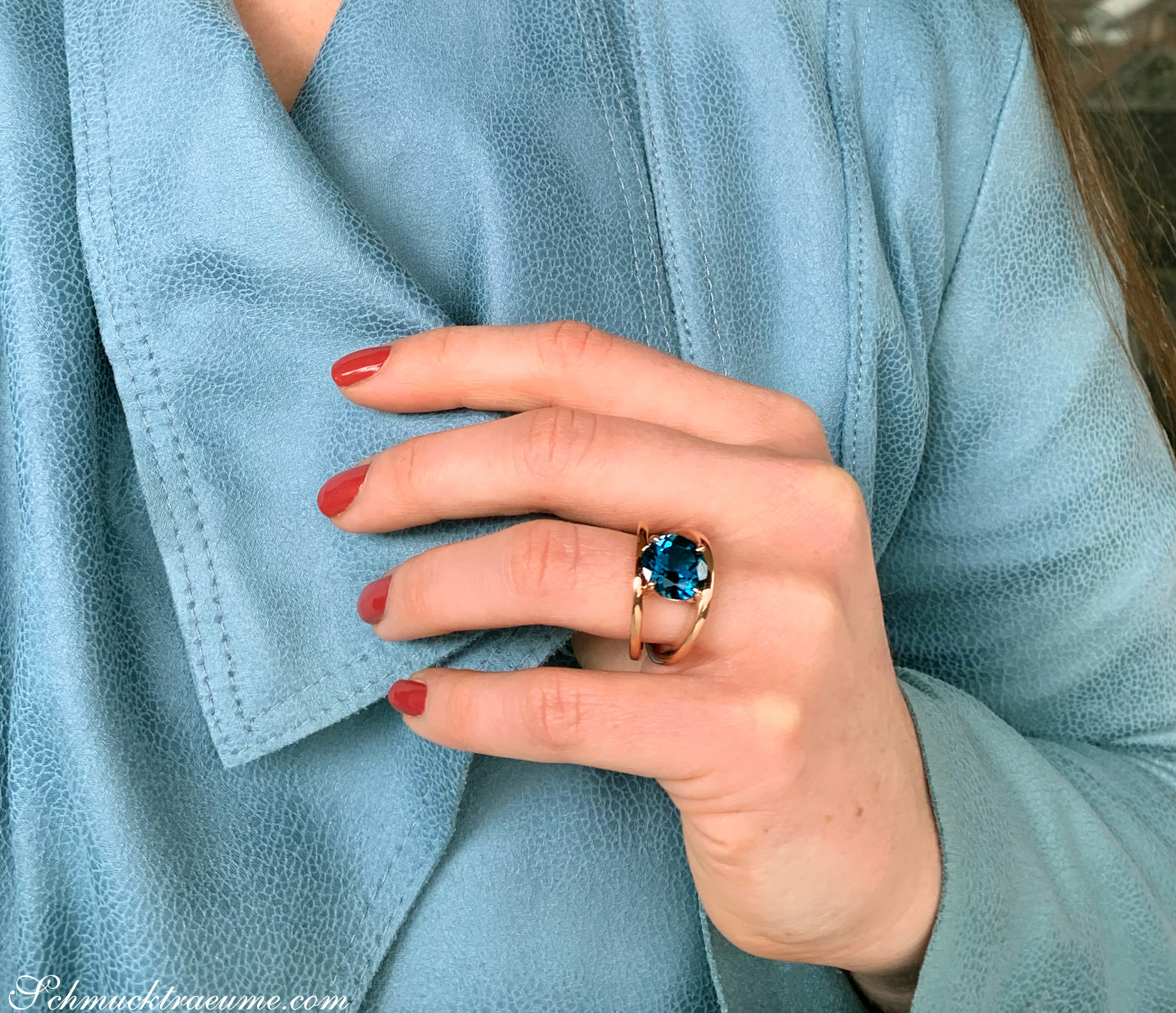 Blautopas-Ring in Roségold 585, detailreiches Design auf blauem Stoff, rote Nagelkunst