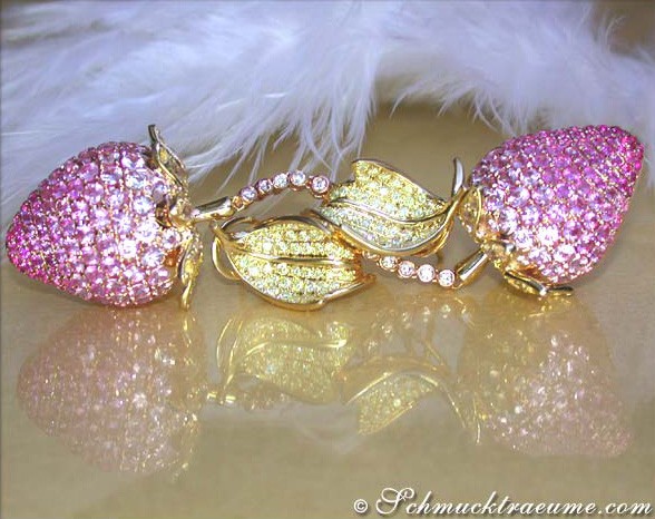 Edelstein-Ohrringe in Erdbeer-Design, pink-gelbe Saphire, goldene Blätter, hochglänzend, auf flauschigem Hintergrund.