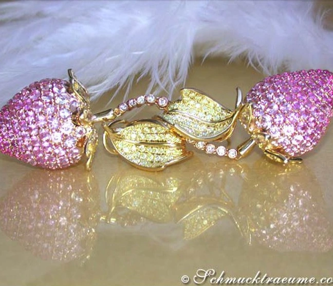 Edelstein-Ohrringe in Erdbeer-Design, pink-gelbe Saphire, goldene Blätter, hochglänzend, auf flauschigem Hintergrund. Edelstein-Ohrringe in Erdbeer-Design, pink-gelbe Saphire, goldene Blätter, hochglänzend, auf flauschigem Hintergrund.