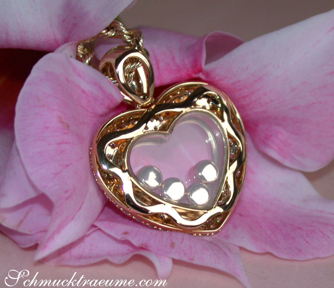 Herz-Anhänger mit Brillanten in Gelbgold vor Rosenblüte