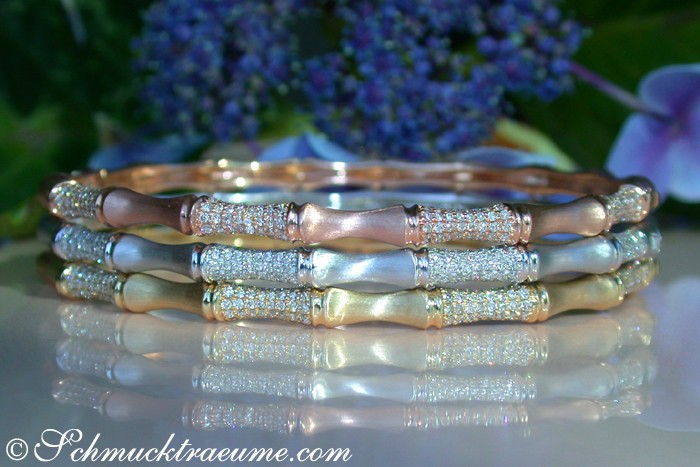 Bambusarmreif aus Roségold mit Diamanten, Detailaufnahme mit Blumen im Hintergrund