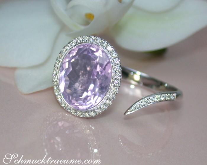 Weißgold-Ring mit Amethyst und Brillanten auf Blütenhintergrund
