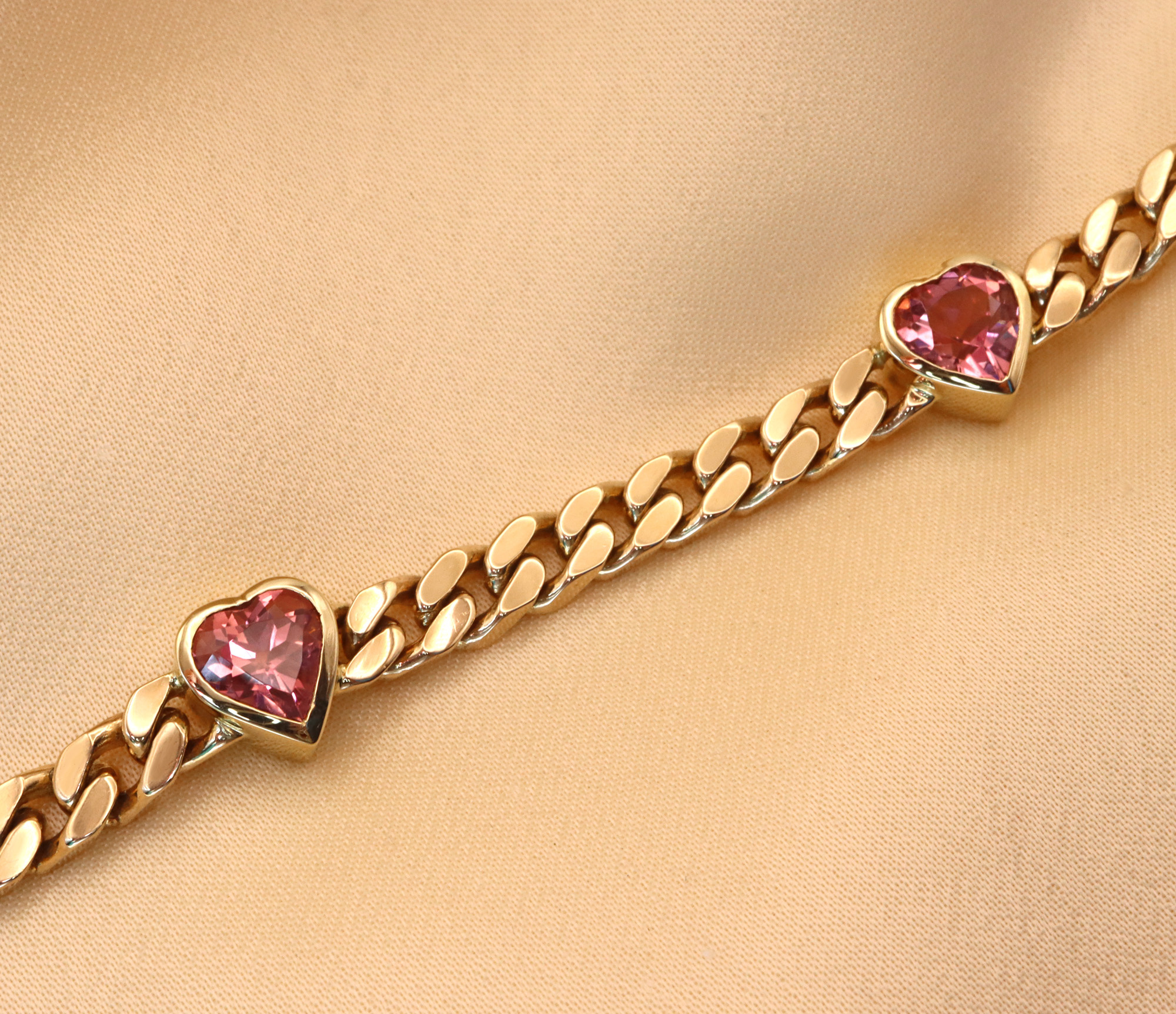 Goldene Panzerarmband mit rosa Herzen, Detailaufnahme, elegant und edel