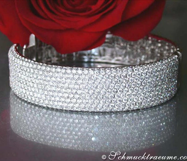Luxus-Diamanten-Armreif in Weißgold, strahlende Brillanten, rote Rose im Hintergrund Luxus-Diamanten-Armreif in Weißgold, strahlende Brillanten, rote Rose im Hintergrund