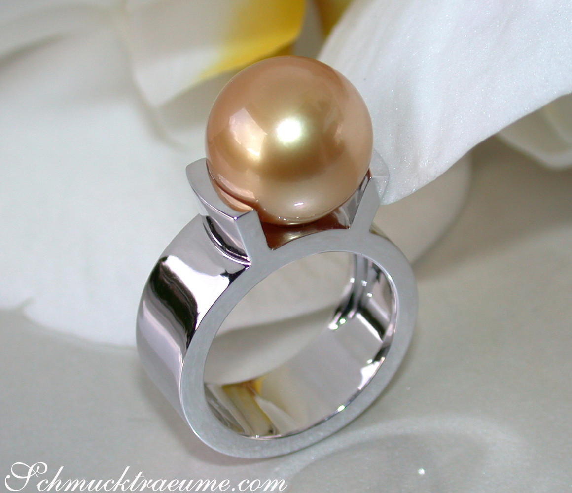 Weißgold-Ring mit goldenem Perlenkugel-Solitär, Detailaufnahme, glänzende Oberfläche, elegant.