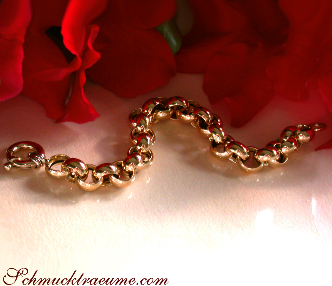 Goldarmband aus Gelbgold 585, Detailaufnahme mit roten Blüten im Hintergrund