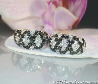 Weißgold-Ohrstecker mit schwarzen und weißen Diamanten im Rauten-Design, Detailaufnahme.