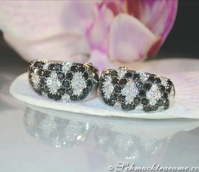 Weißgold-Ohrstecker mit schwarzen und weißen Diamanten im Rauten-Design, Detailaufnahme. Weißgold-Ohrstecker mit schwarzen und weißen Diamanten im Rauten-Design, Detailaufnahme.