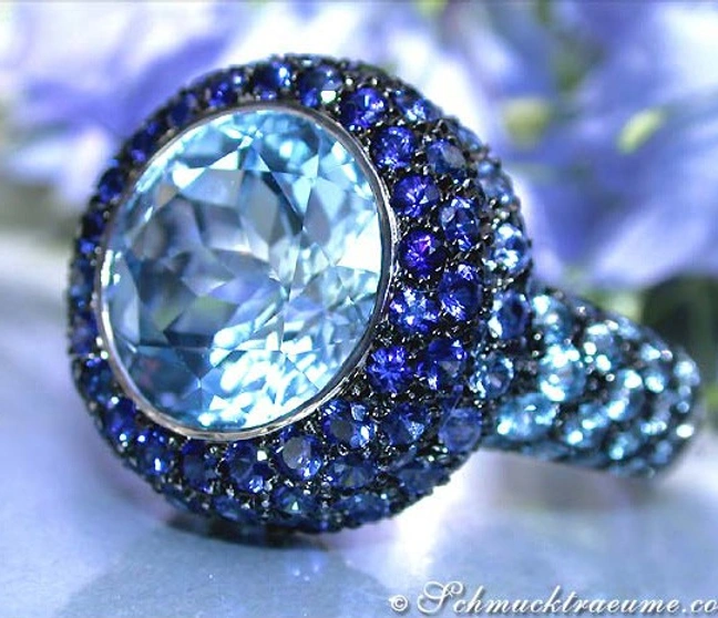 Weißgoldring mit blauem Zentraledelstein und umlaufenden Saphiren, Detailaufnahme. Weißgoldring mit blauem Zentraledelstein und umlaufenden Saphiren, Detailaufnahme.