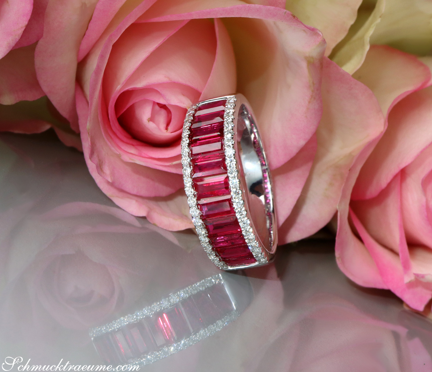 Rosenblüten im Hintergrund, Rubin-Baguette-Ring mit Brillanten, elegant und fein.