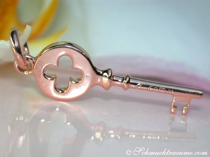 Roségold Schlüsselanhänger mit Diamanten, Detailaufnahme, zartes Design, Blume im Hintergrund