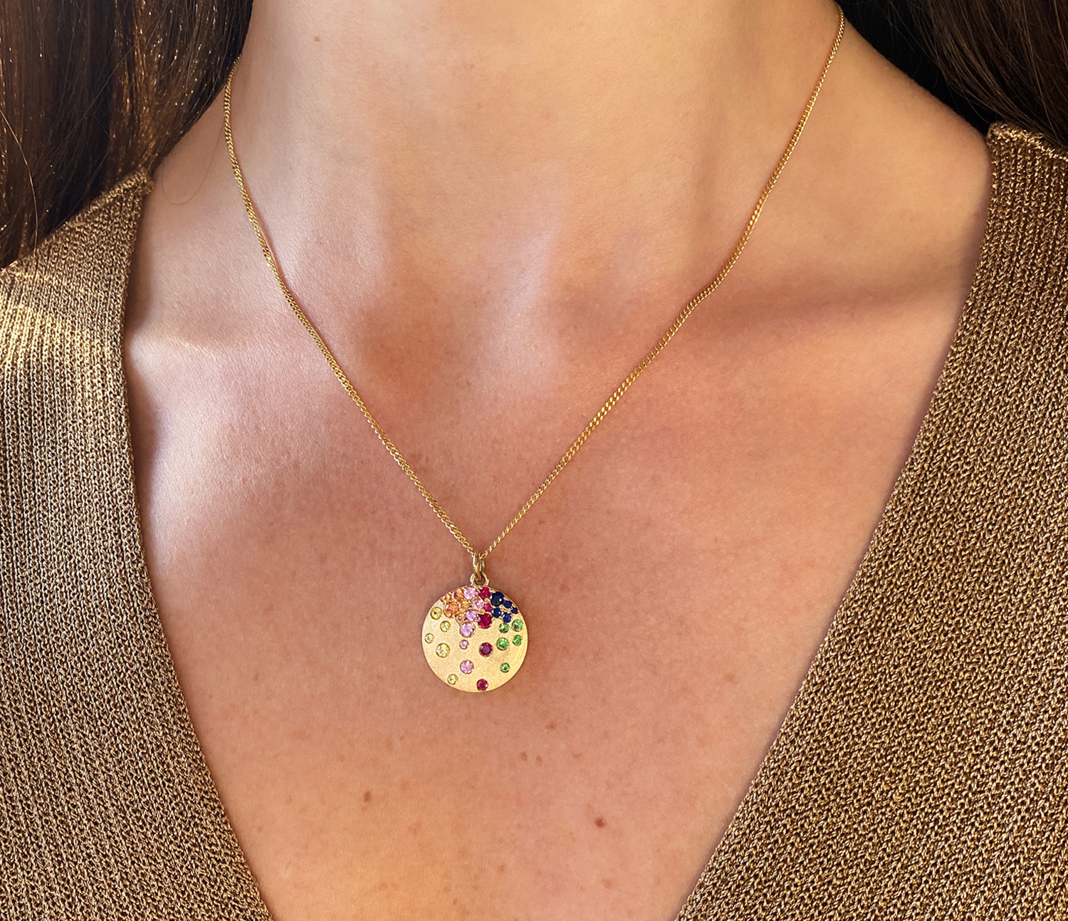 Goldene Halskette mit farbigem Saphir-Medaillon getragen