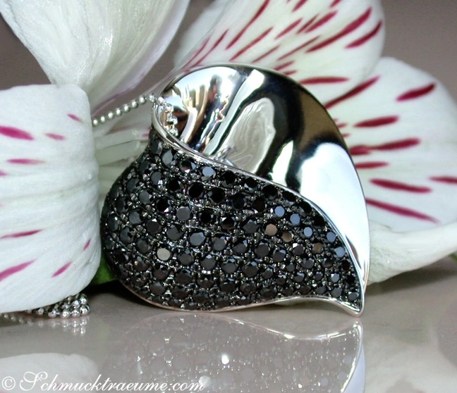 Schwarzer Diamant Herzanhänger mit Weißgold, Detailaufnahme, elegant, feminin, dunkle Perlen, Orchideenblüte im Hintergrund Schwarzer Diamant Herzanhänger mit Weißgold, Detailaufnahme, elegant, feminin, dunkle Perlen, Orchideenblüte im Hintergrund