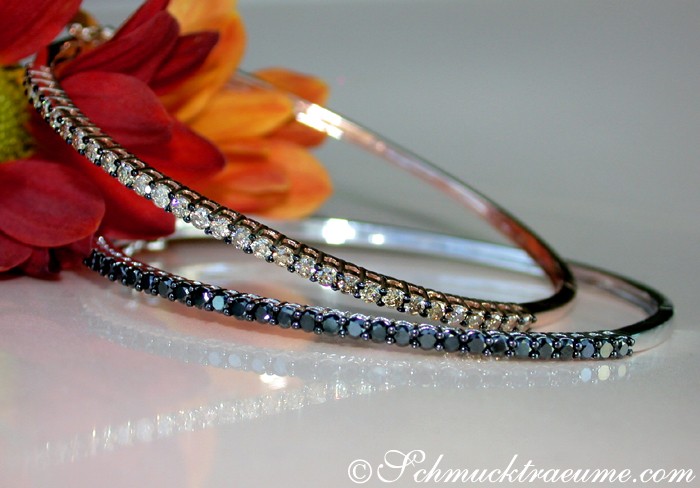 Weißgold-Armreif mit schwarzen Diamanten, Detailaufnahme, blühende Blume im Hintergrund