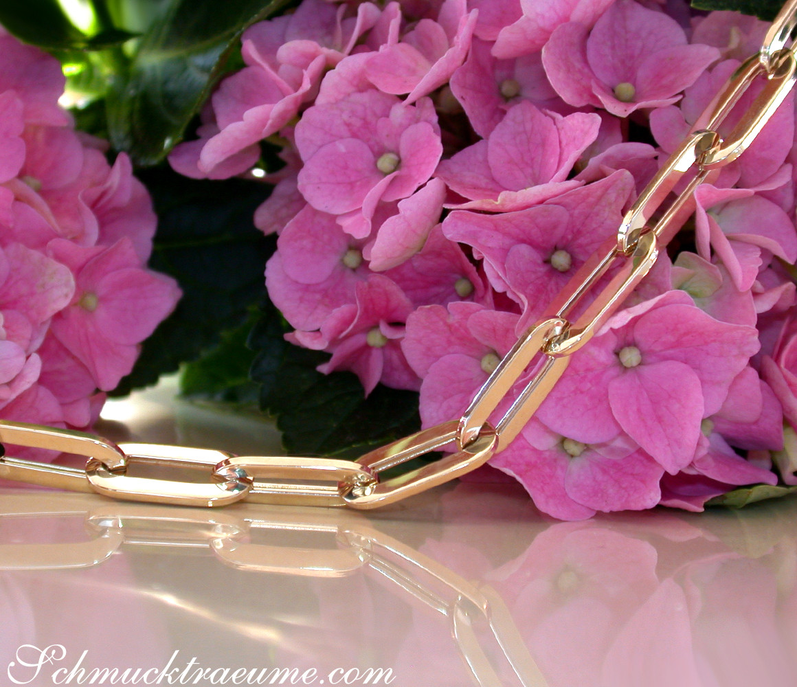 Gelbgold-Paperclip-Halskette auf rosa Hortensienblüten, Detailaufnahme