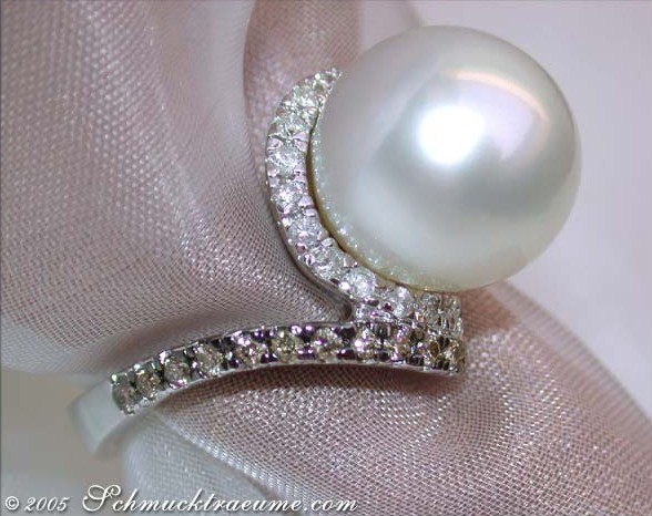 Weißgoldring mit Perle und Brillanten auf Satin.