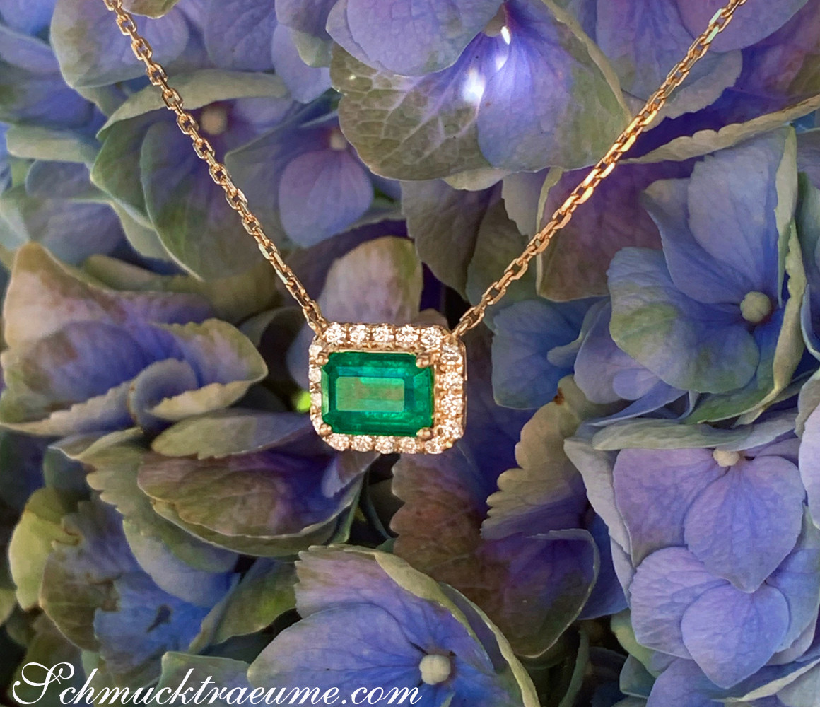Blütenhintergrund mit Smaragd-Halskette und Brillanten in Gelbgold 585