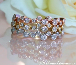 Drei Diamant-Ringe aus Weiß-, Gelb- & Roségold 585, detailreich, auf Blüte abgebildet.