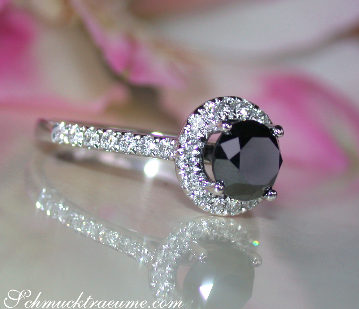 Schwarzer Diamant Solitär-Ring mit Halo-Design in Weißgold 585, detailreich, vor Rosenblättern.