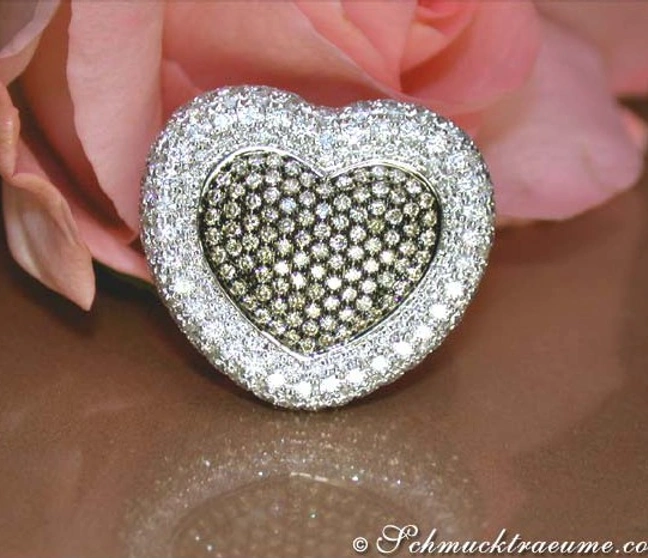 Herzring aus Weißgold mit braunen und weißen Brillanten, detailreich, auf Rosenblüte liegend. Herzring aus Weißgold mit braunen und weißen Brillanten, detailreich, auf Rosenblüte liegend.