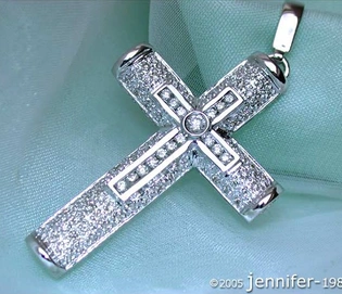 Weißgold Kreuzanhänger mit Diamanten, Detailaufnahme auf grünem Stoff.