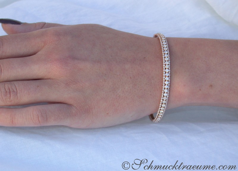 Detailaufnahme des Brillantenarmreifs in Roségold, auf weißem Hintergrund getragen