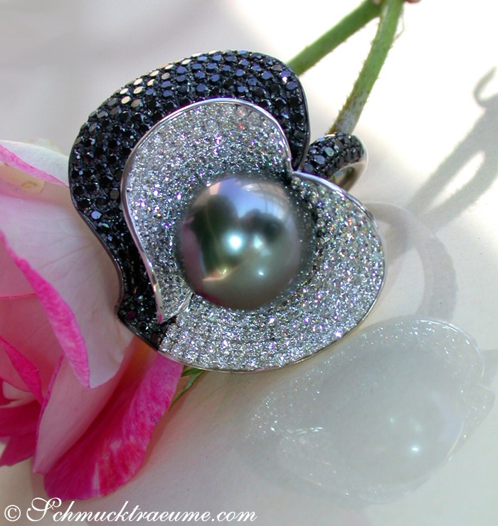 Tahitiperlenring mit schwarzen Diamanten und weißen Brillanten, großes Perlenzentrum, Detailaufnahme auf Blume.