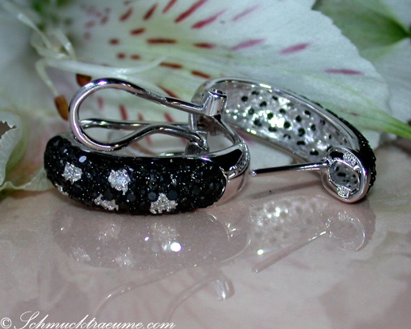 Schwarze Diamanten Ohrringe im Tupfen-Design auf weißem Blütenhintergrund