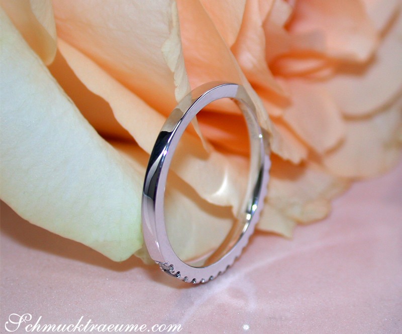 Halb Memoryring aus Weißgold mit schwarzen und weißen Diamanten, detailgetreu auf Rosenblatt gezeigt.