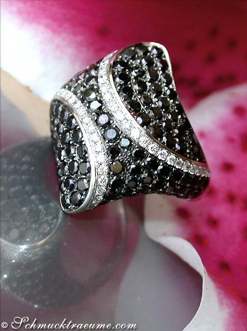 Detaillierter schwarzer Diamant-Ring im Rauten-Design auf rosa Blütenblatt, 585 Weißgold.