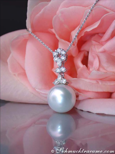 Südseeperlen-Anhänger mit Diamanten auf Kette, rosa Blume im Hintergrund