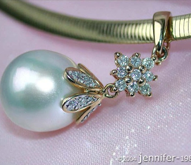 Goldener Perlenanhänger mit Diamantblüte, Detailaufnahme auf zarter Kette Goldener Perlenanhänger mit Diamantblüte, Detailaufnahme auf zarter Kette