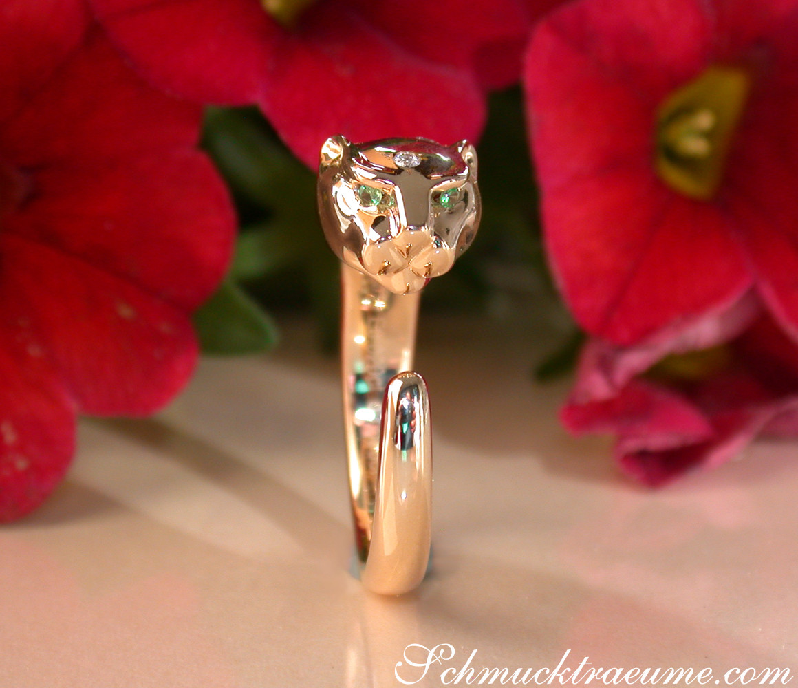 Goldener Panther-Ring mit Brillanten in Gelbgold 750, Detailaufnahme, vor roten Blüten.