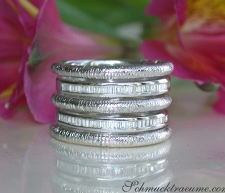 Silberne Ringstapel mit Textur auf weißem Hintergrund