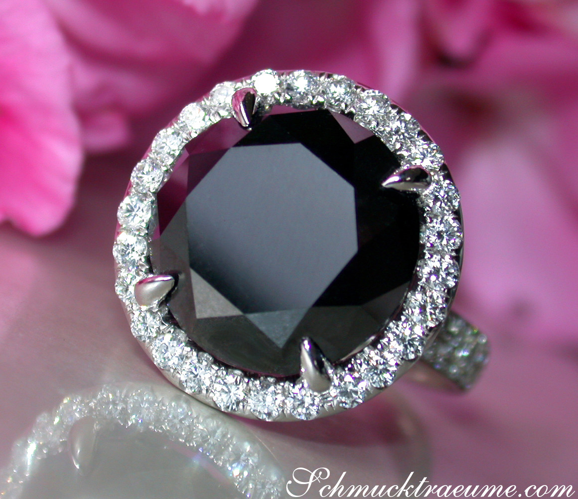 Schwarzdiamant-Solitär-Ring mit Brillanten in Weißgold 750, Detailaufnahme, rosa Hintergrund.