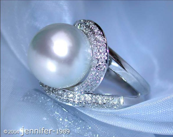 Schneeweißer Perlenring mit Brillanten in Weißgold, detailreich auf Satin präsentiert