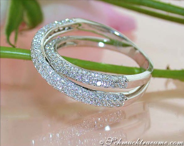 Detailbild des überkreuzten Weißgoldringes mit Brillanten auf glattem Untergrund