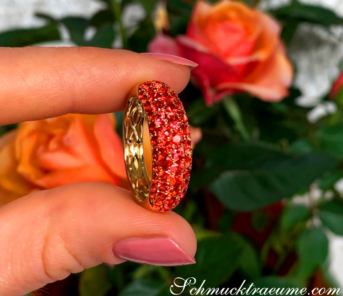 Orange Saphir Pavéring in Gelbgold, Detailaufnahme vor Rosenblüten