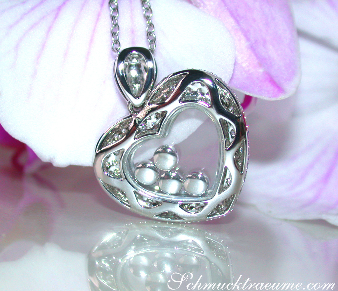 Femininer Brillanten-Herz-Anhänger mit Diamanten und Perlen, verziert in Weißgold 750, auf Orchideenblüte.