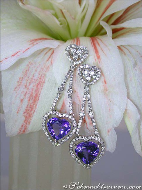 Herzformige Tansanit-Ohrringe mit Diamanten, elegant auf Blüte präsentiert