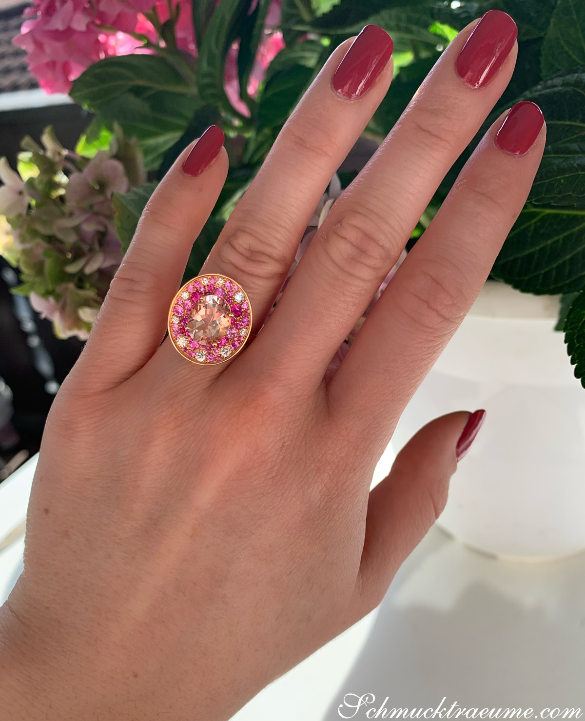 Rosenkunst: Hand mit roten Nägeln, Ring mit Morganit und Pink Saphiren