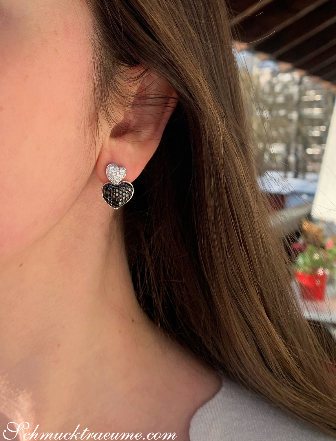 Ohrstecker Herzform mit schwarzen und weißen Diamanten, Detailaufnahme.