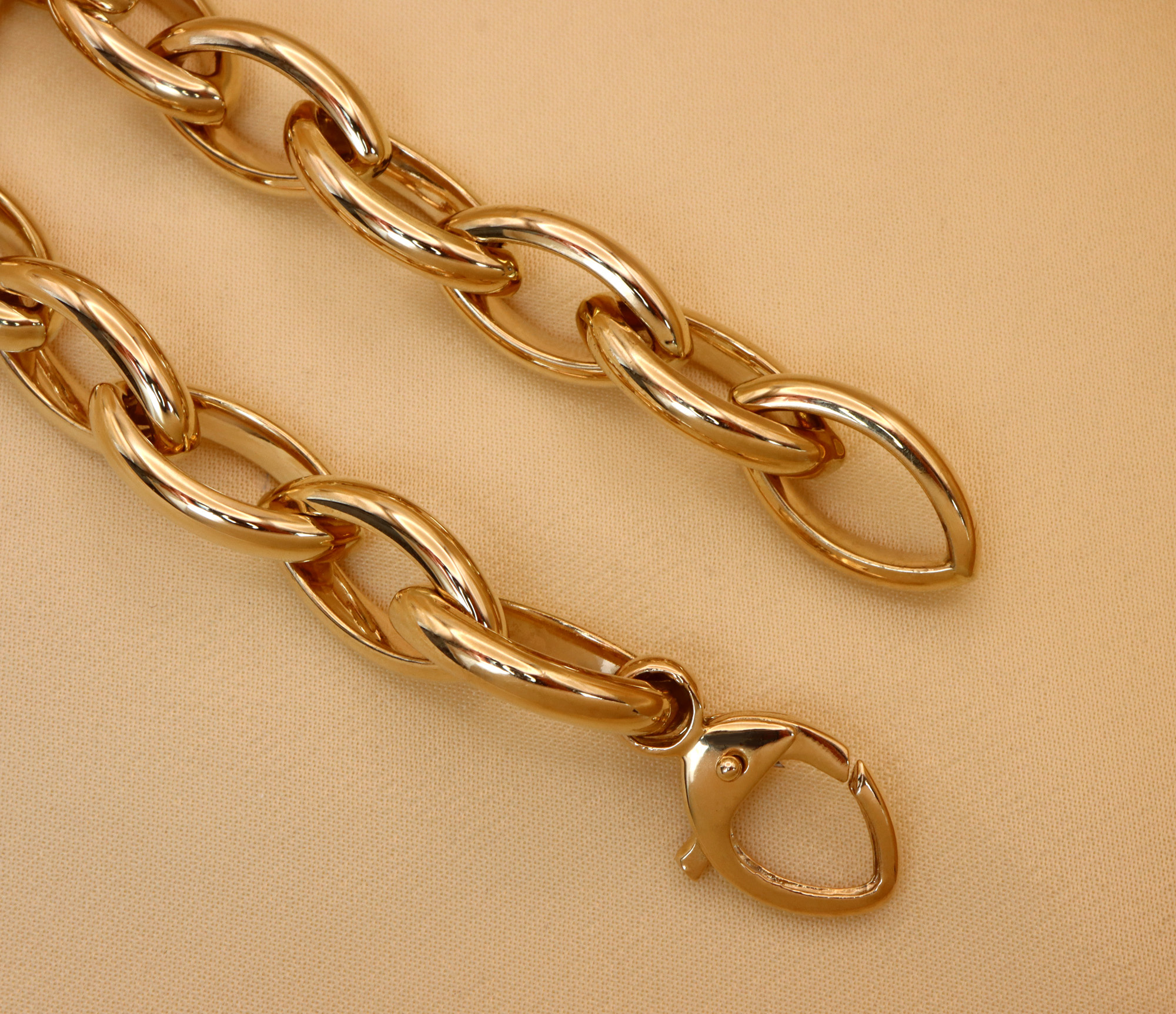 Goldene Navette-Armbandkette aus Gelbgold 585, glänzende Verbindungsdetails, elegant auf beige Hintergrund.